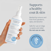 Hand holding a bottle of Veterinary Formula Flea & Tick Spray with product details on a light gray background.