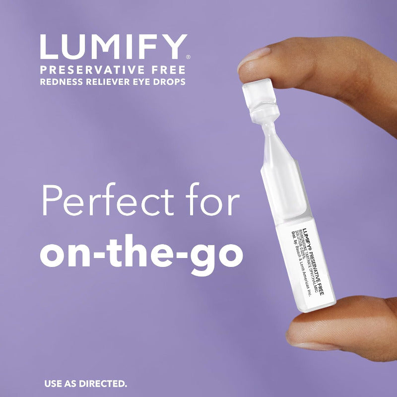 A hand holds a small white Lumify preservative-free redness reliever eye drop Vial against a lavender background with promotional text.