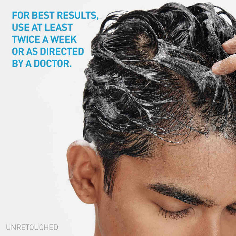 Close-up of a man's scalp with dark hair covered in Cerave 2 in 1 Anti-Dandruff Hydrating Shampoo & Conditioner lather, with a hand washing the hair. Blue text on the left reads, 'FOR BEST RESULTS, USE AT LEAST TWICE A WEEK OR AS DIRECTED BY A DOCTOR.
