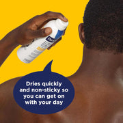 A person shown from the back with a hand spraying a PanOxyl Acne Banishing Body Spray  bottle onto the skin. A dark blue speech bubble says it dries quickly and non-sticky so you can get on with your day, against a bright yellow background.