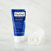 PanOxyl Acne Foaming Wash Maximum Strength bottle next to a rolled up towel, on top of a marble sideboard