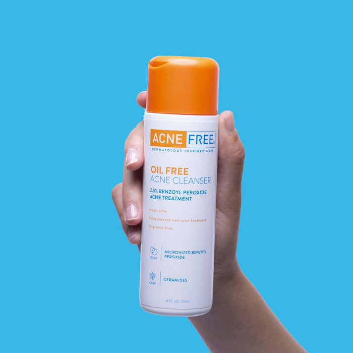 AcneFree Oil Free Acne Cleanser 8 Oz Banner Showing  A Hand Holding Product Bottle In Front Of Blue Background.