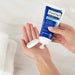 woman squirting PanOxyl Acne Creamy Wash Benzoyl Peroxide 4% Daily Control, 6  oz  into her hand prior to washing