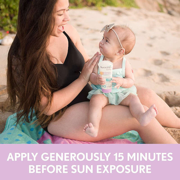 Aveeno Baby Continuous Protection Zinc Oxide Mineral Sunscreen Banner showing a woman and baby at beach. Headline reads - Apply Generously 15 minutes before sun exposure.